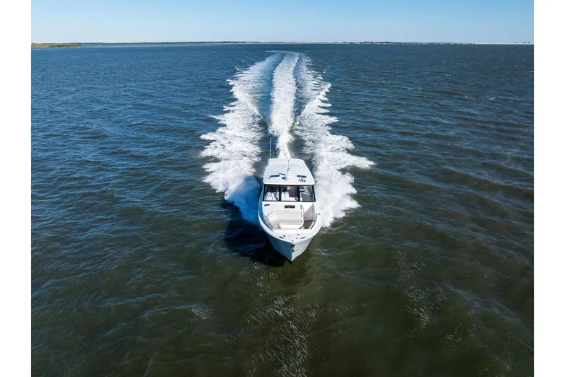 Slide: The Image of 2025 MJM 4 boat cruising on open water, leaving a wake trail. - 47