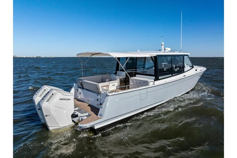 Slide: The Image of 2025 MJM 4 boat cruising on open water with twin Mercury engines. - 50