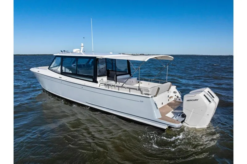 Slide: The Image of 2025 MJM 4 boat cruising on open water with Mercury outboard engines. - 51