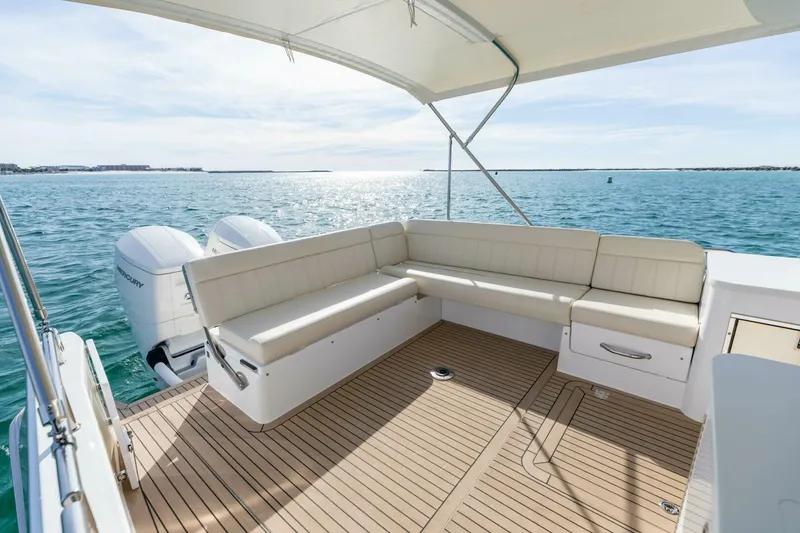 Slide: The Image of Luxury MJM 4 boat deck with seating, overlooking serene ocean waters, 2025 model. - 34