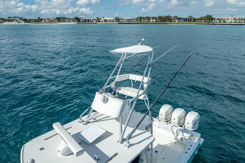 Slide: The Image of 2017 SeaVee 370Z boat with tower and triple engines on calm ocean near coastline. - 11