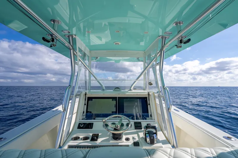 Slide: The Image of 2017 SeaVee 370Z boat helm with ocean view, featuring modern controls and turquoise canopy. - 46