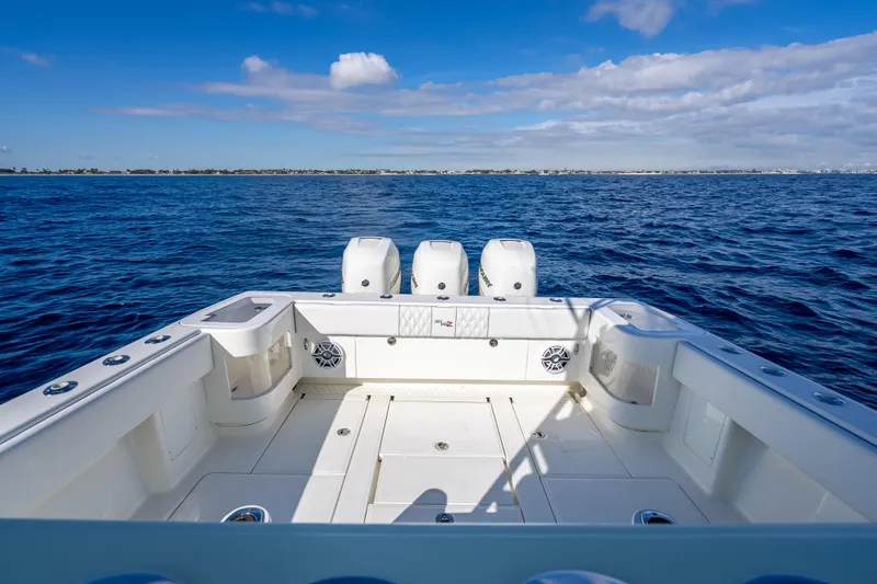Slide: The Image of 2017 SeaVee 370Z boat on open ocean, featuring triple outboard engines. - 47