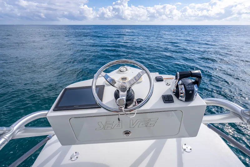 Slide: The Image of 2017 SeaVee 370Z boat helm with ocean view, featuring steering wheel and controls. - 60