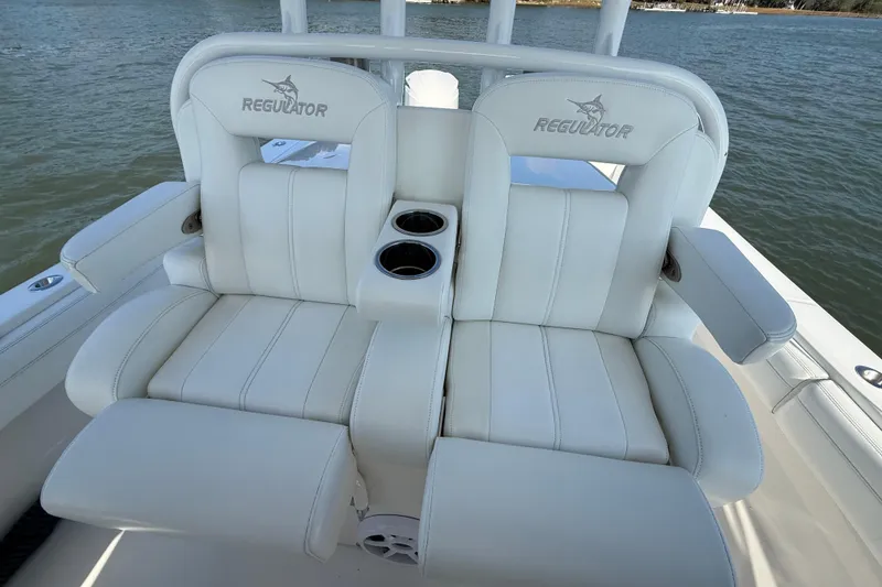 Slide: The Image of 2020 Regulator 31 boat seats with cup holders on a calm water backdrop. - 19