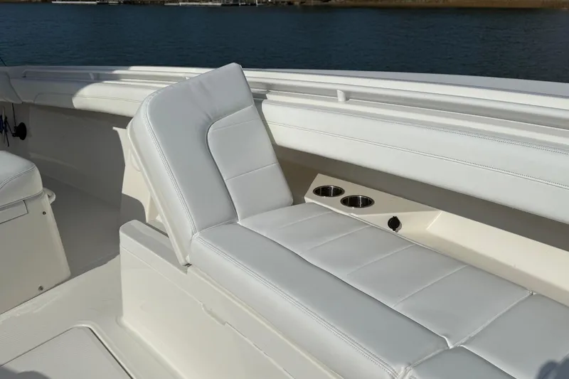 Slide: The Image of 2020 Regulator 31 boat interior with white cushioned seating and cup holders. - 26