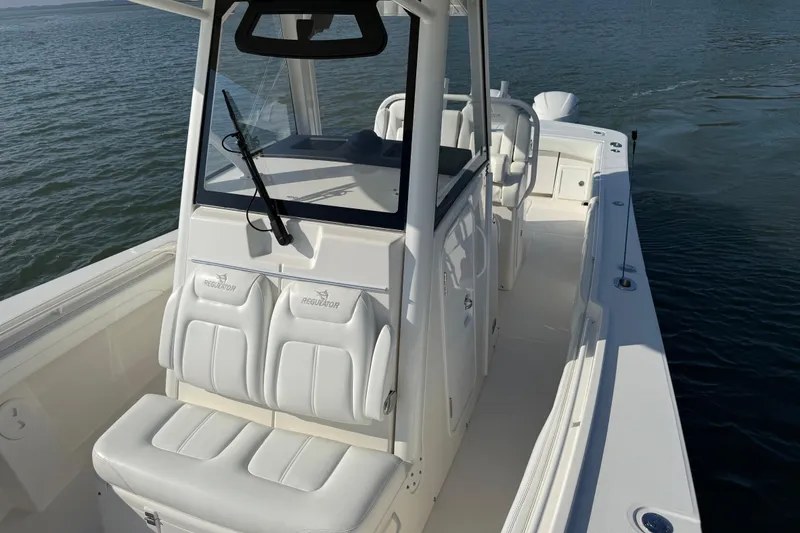 Slide: The Image of 2020 Regulator 31 boat with white seating, cruising on calm water. - 28