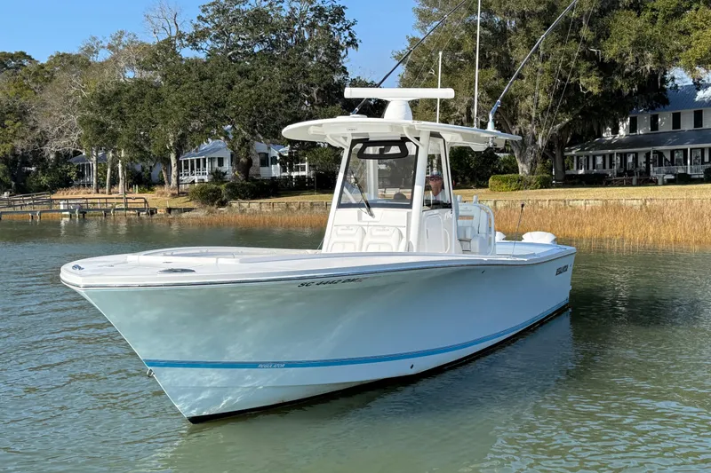 Slide: The Image of 2020 Regulator 31 boat on calm water near shoreline with trees and houses. - 3