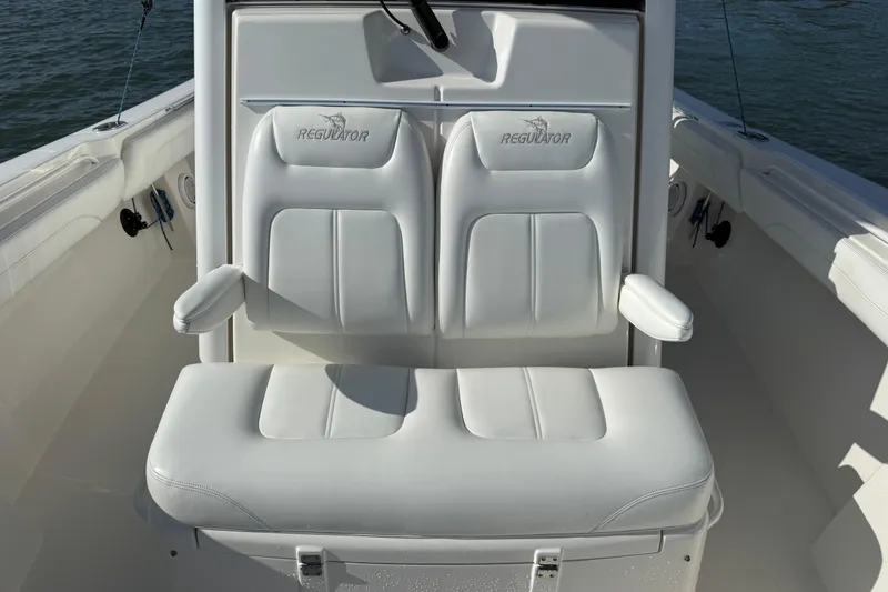 Slide: The Image of 2020 Regulator 31 boat with white cushioned seating and armrests on deck. - 31