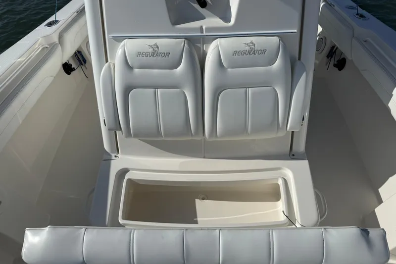 Slide: The Image of 2020 Regulator 31 boat interior with cushioned seating and storage compartment. - 32