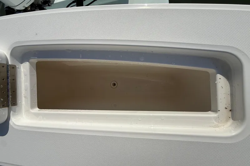 Slide: The Image of 2020 Regulator 31 boat storage compartment, open and empty, with visible hinge. - 36