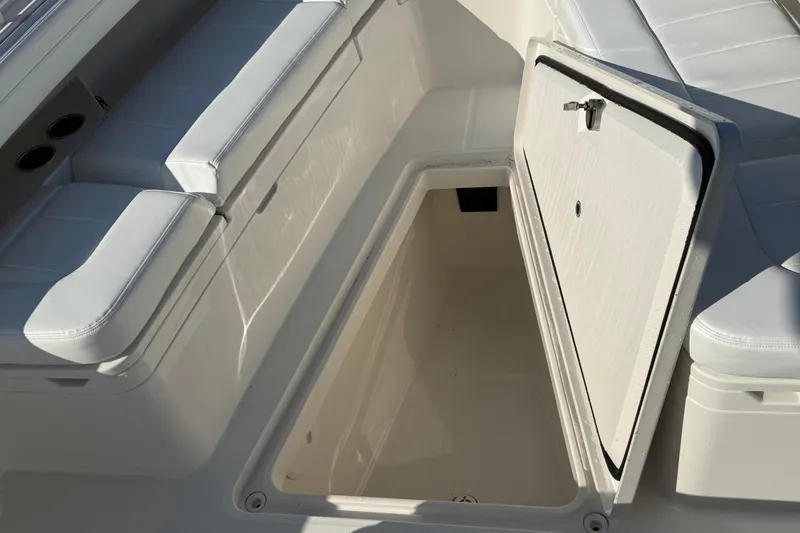 Slide: The Image of 2020 Regulator 31 boat with open storage compartment and cushioned seating. - 37