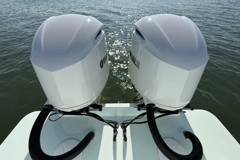 Slide: The Image of Twin outboard motors on a 2020 Regulator 31 boat, glistening on the water. - 39