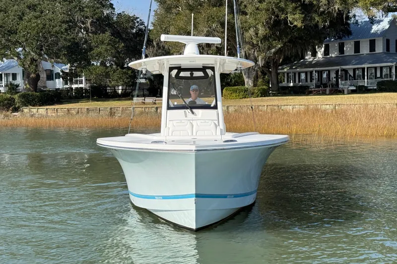 Slide: The Image of 2020 Regulator 31 boat on calm water near a shoreline with trees and houses. - 4