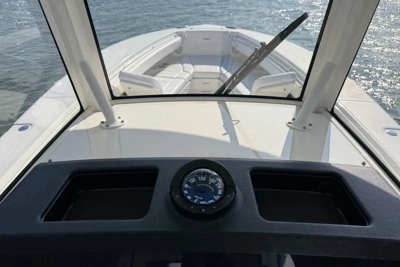 Slide: The Image of 2020 Regulator 31 boat interior with compass, windshield, and seating on water. - 8