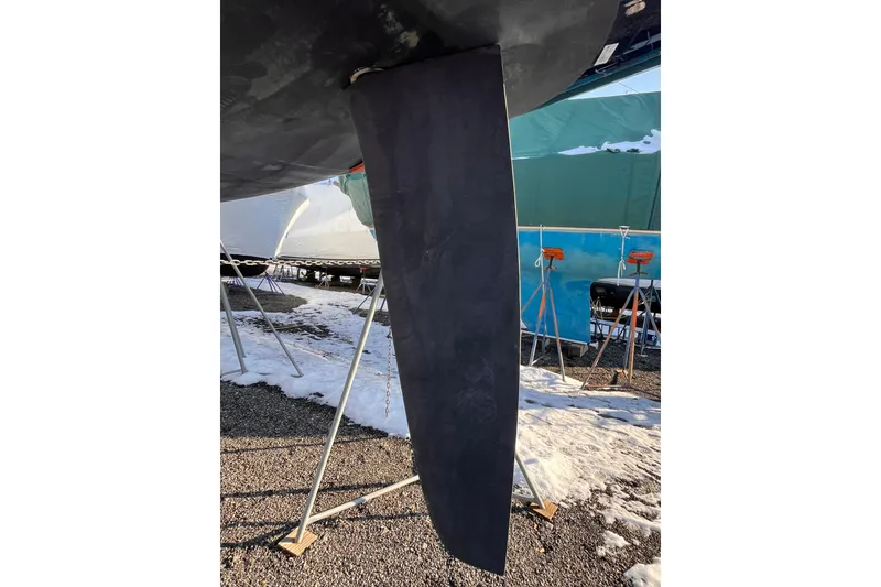 Slide: The Image of Rudder of 2007 Beneteau First 10R sailboat on a snowy boatyard. - 17