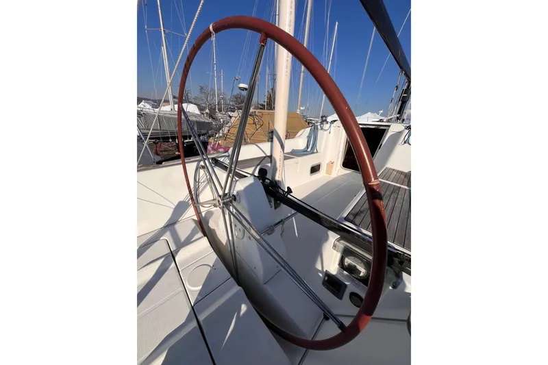 Slide: The Image of 2007 Beneteau First 10R sailboat cockpit with large steering wheel, docked in marina. - 23