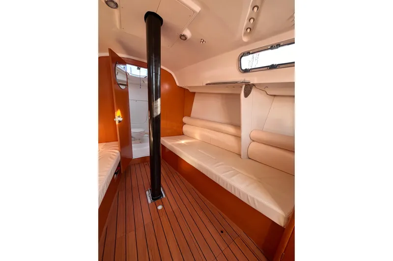 Slide: The Image of Interior of 2007 Beneteau First 10R sailboat with wooden flooring and seating. - 65