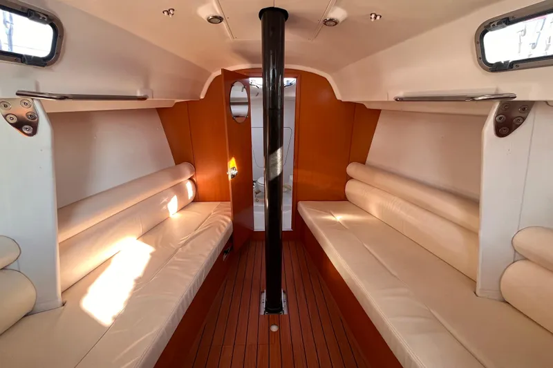 Slide: The Image of Interior of 2007 Beneteau First 10R sailboat with sleek seating and wooden accents. - 66