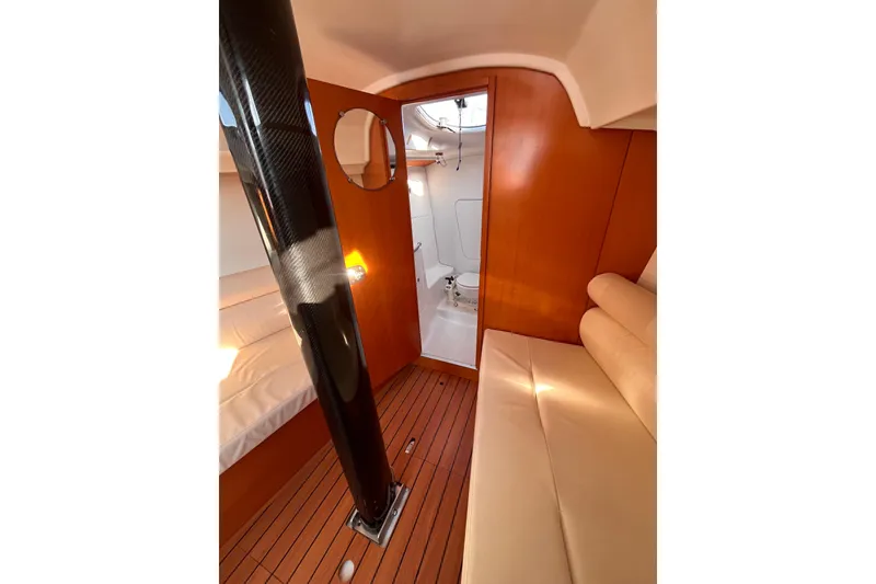 Slide: The Image of Interior of 2007 Beneteau First 10R sailboat, featuring wood paneling and seating. - 67