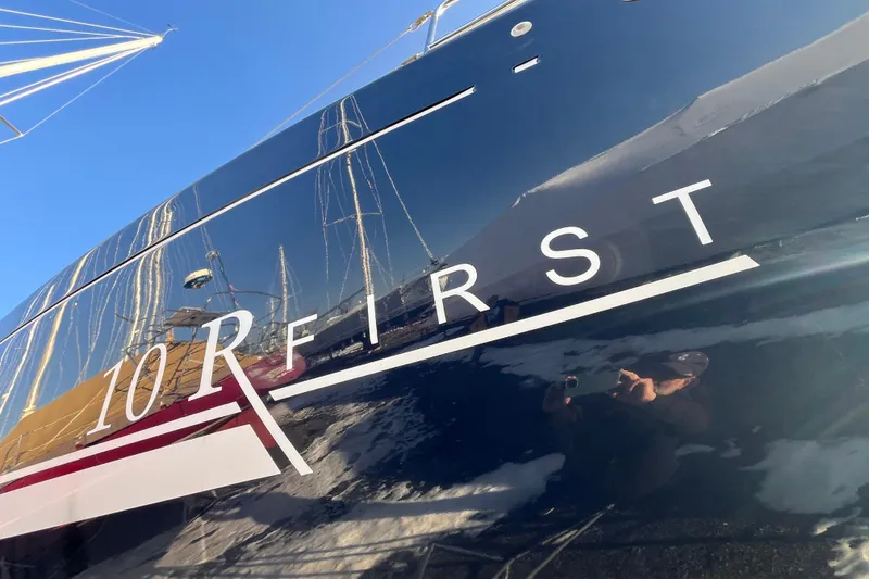 Slide: The Image of 2007 Beneteau First 10R sailboat with reflective hull and clear blue sky. - 7