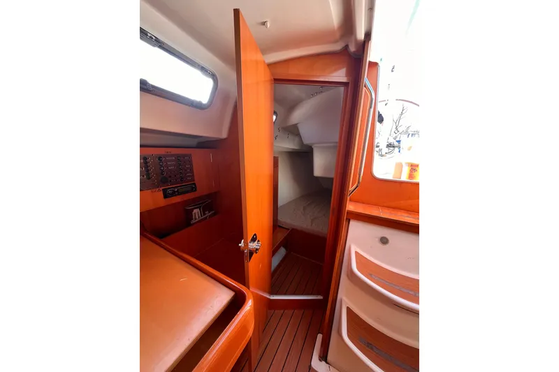 Slide: The Image of 2007 Beneteau First 10R cabin interior with wood finish and navigation panel. - 79