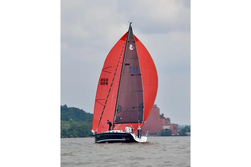 Slide: The Image of 2007 Beneteau First 10R sailboat with red spinnaker on a cloudy day. - 85