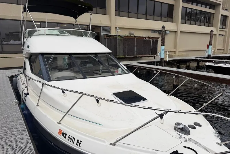 Slide: The Image of 2001 Bayliner 3258 Command Bridge docked at a marina, featuring sleek design and spacious deck. - 1