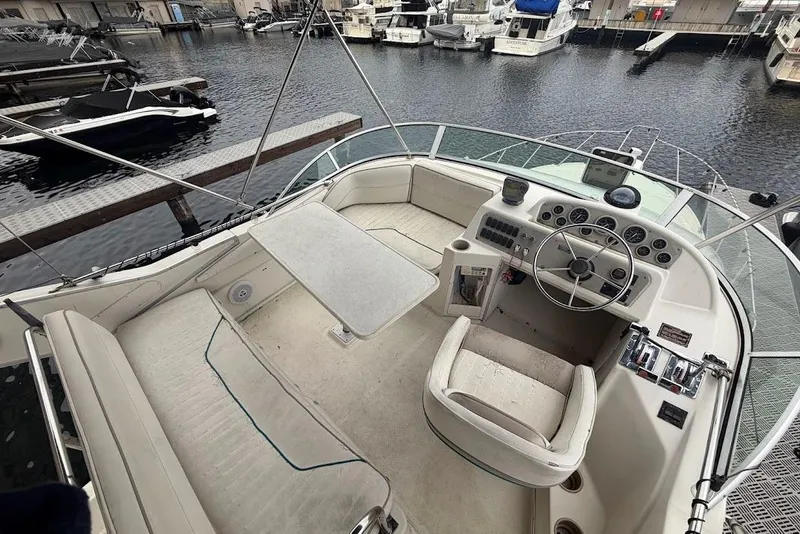 Slide: The Image of 2001 Bayliner 3258 Command Bridge boat interior at marina, featuring helm and seating area. - 12