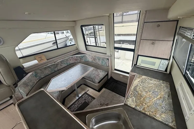 Slide: The Image of Interior of 2001 Bayliner 3258 Command Bridge with seating, table, and kitchenette. - 2
