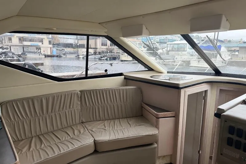 Slide: The Image of Interior of 2001 Bayliner 3258 Command Bridge with beige seating and marina view. - 3