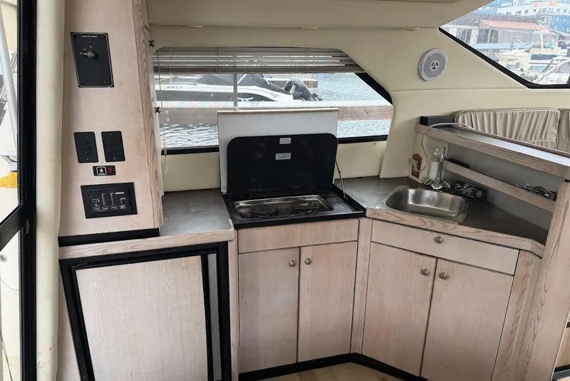 Slide: The Image of 2001 Bayliner 3258 Command Bridge interior kitchen with stove, sink, and cabinets. - 5