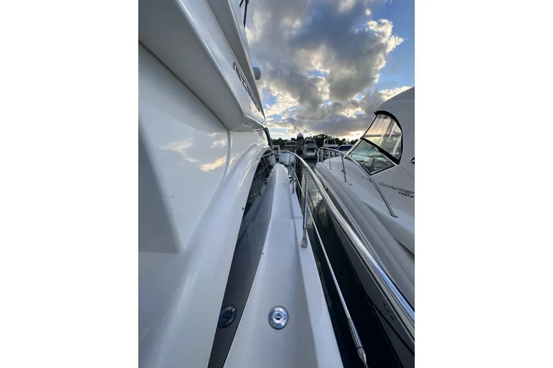 Slide: The Image of 2011 Azimut 38 yacht docked under a cloudy sky, showcasing sleek design. - 5