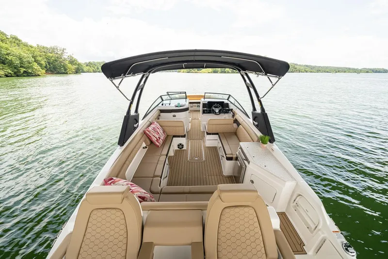 Slide: The Image of Manufacturer Provided Image: 2023 Sea Ray SDX 290 boat interior with tan seating and black canopy on a lake. - 10