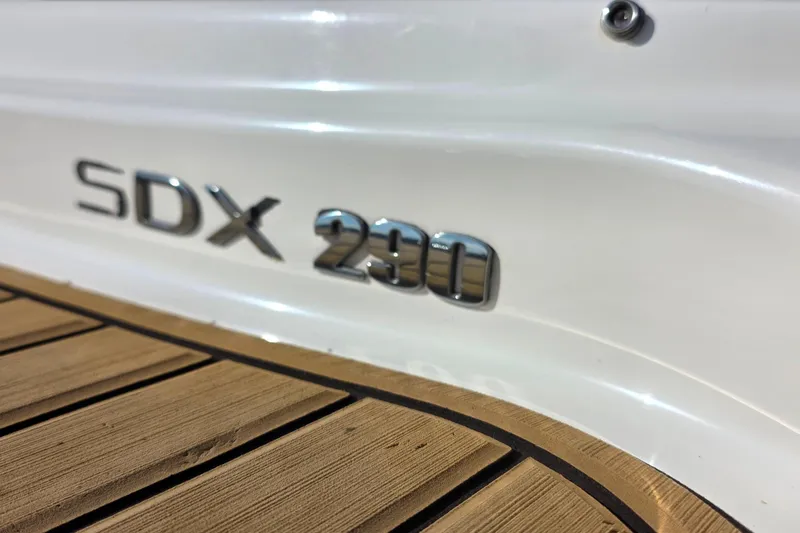 Slide: The Image of 2023 Sea Ray SDX 290 boat logo on sleek white hull with wooden deck. - 16