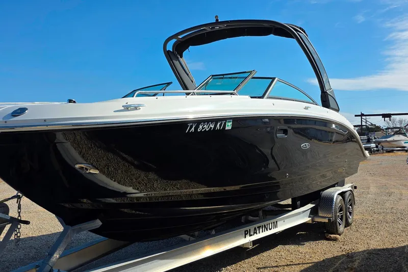 Slide: The Image of 2023 Sea Ray SDX 290 boat on trailer under clear blue sky. - 19