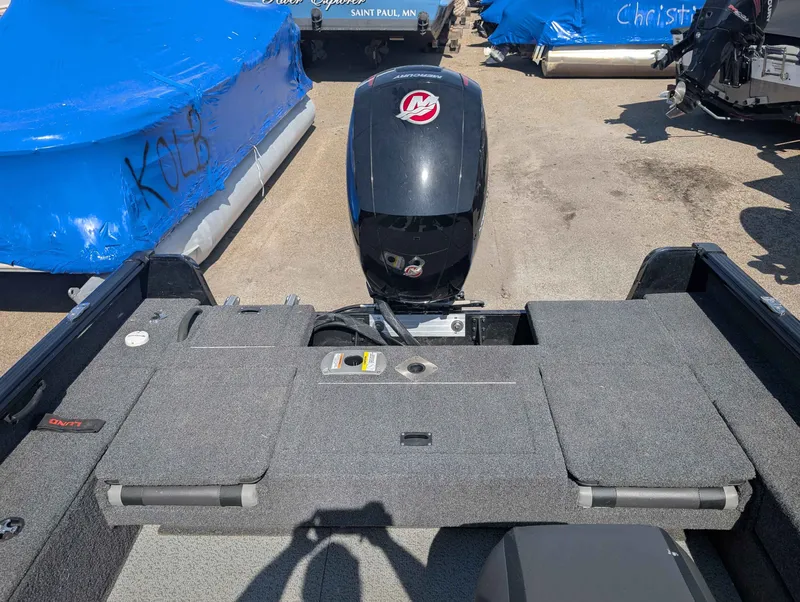 Slide: The Image of 2023 Lund 1875 Impact boat with Mercury engine, parked outdoors. - 12