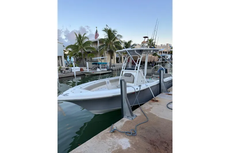 The Image of 2021 Key West 239 FS boat docked by palm trees and waterfront homes. - 1