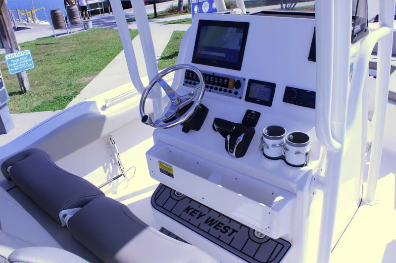 Slide: The Image of 2021 Key West 239 FS boat cockpit with steering wheel and navigation controls. - 10