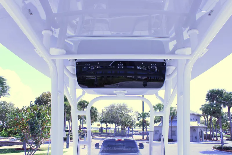 Slide: The Image of 2021 Key West 239 FS boat interior view with T-top and electronics, parked outdoors. - 12