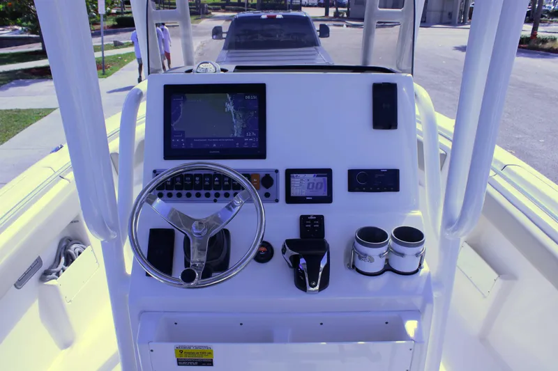 Slide: The Image of 2021 Key West 239 FS boat console with steering wheel, navigation display, and controls. - 13