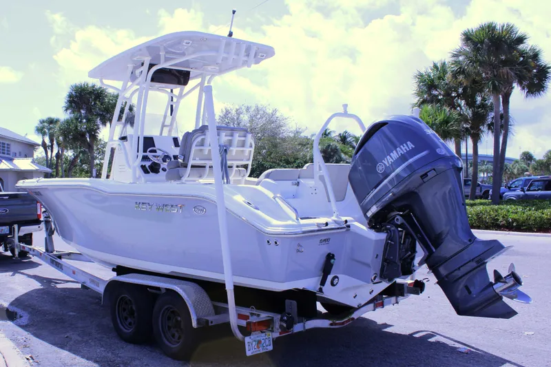Slide: The Image of 2021 Key West 239 FS boat on trailer with Yamaha outboard motor, parked outdoors. - 15