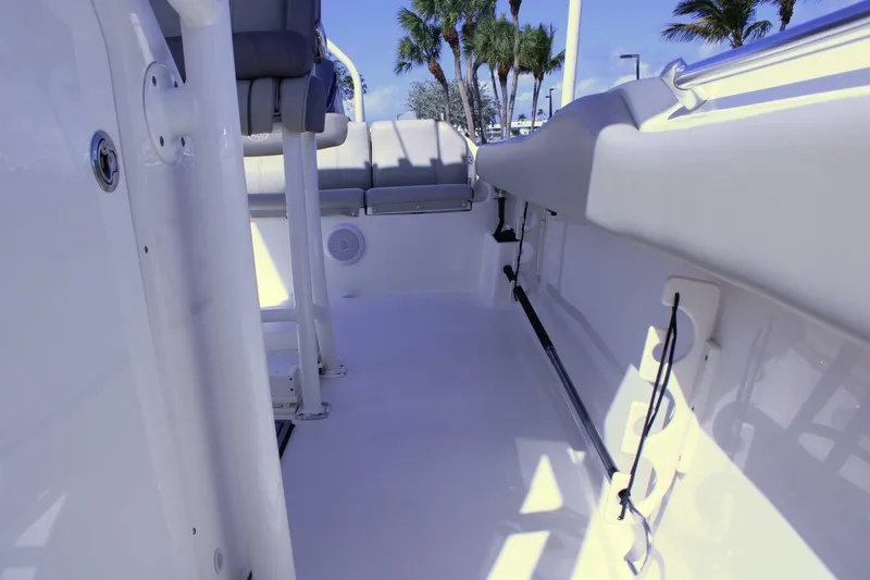 Slide: The Image of 2021 Key West 239 FS boat interior with seating and storage, palm trees in background. - 20