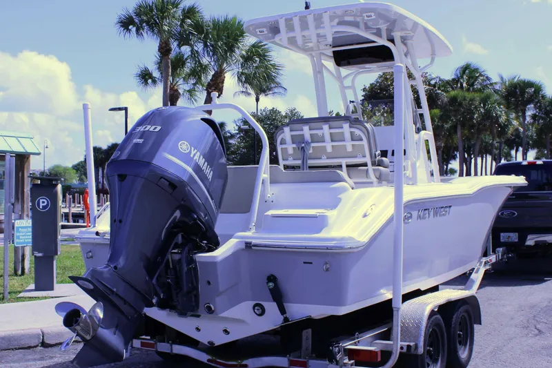 Slide: The Image of 2021 Key West 239 FS boat with Yamaha engine on trailer, parked near palm trees. - 24