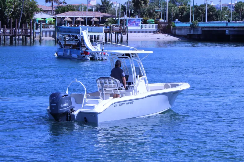 Slide: The Image of 2021 Key West 239 FS boat cruising on clear blue water near a dock. - 3
