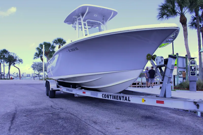 Slide: The Image of 2021 Key West 239 FS boat on trailer, parked near palm trees. - 5
