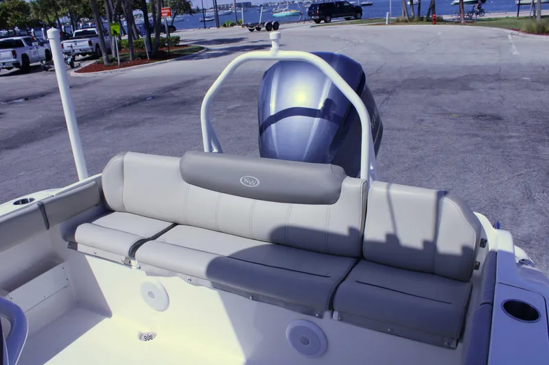 Slide: The Image of 2021 Key West 239 FS boat with cushioned seating and outboard motor at a dock. - 7