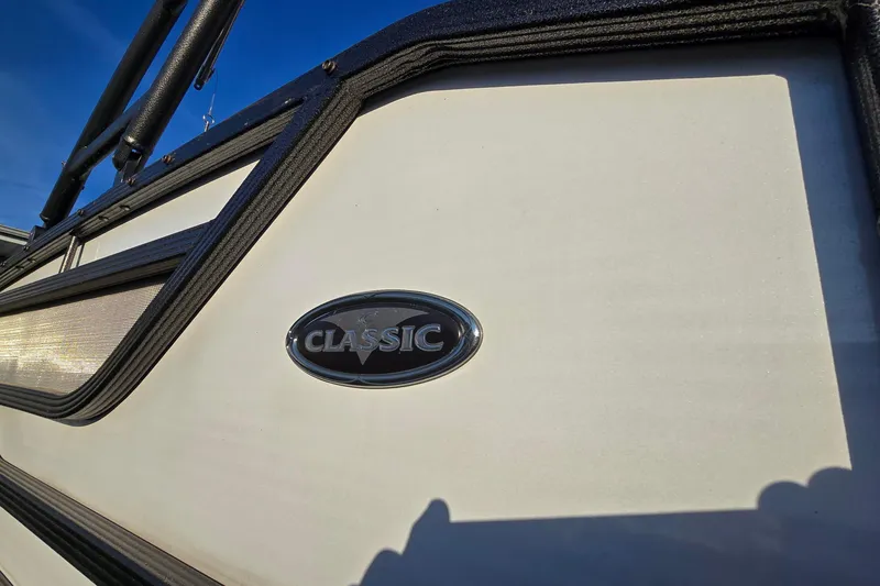 Slide: The Image of 2017 Crest Classic 230 SLC boat emblem on white exterior under blue sky. - 11