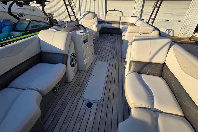 Slide: The Image of 2017 Crest Classic 230 SLC pontoon boat interior with luxurious seating and wood flooring. - 14