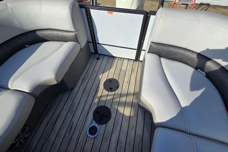 Slide: The Image of Interior of 2017 Crest Classic 230 SLC boat with cushioned seating and wooden flooring. - 16